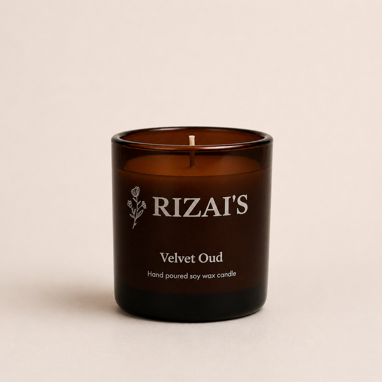 Rizai's Velvet Oud candle in a amber jar container on a beige background